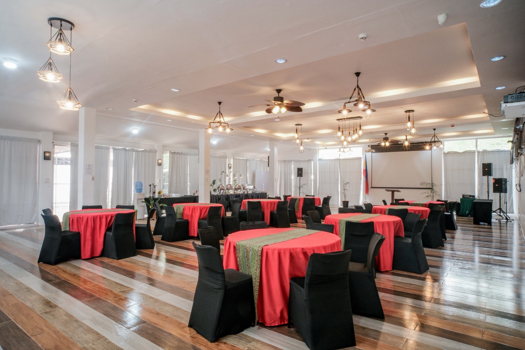 Andrea Garden Hall set with round banquet tables and a head-table backdrop