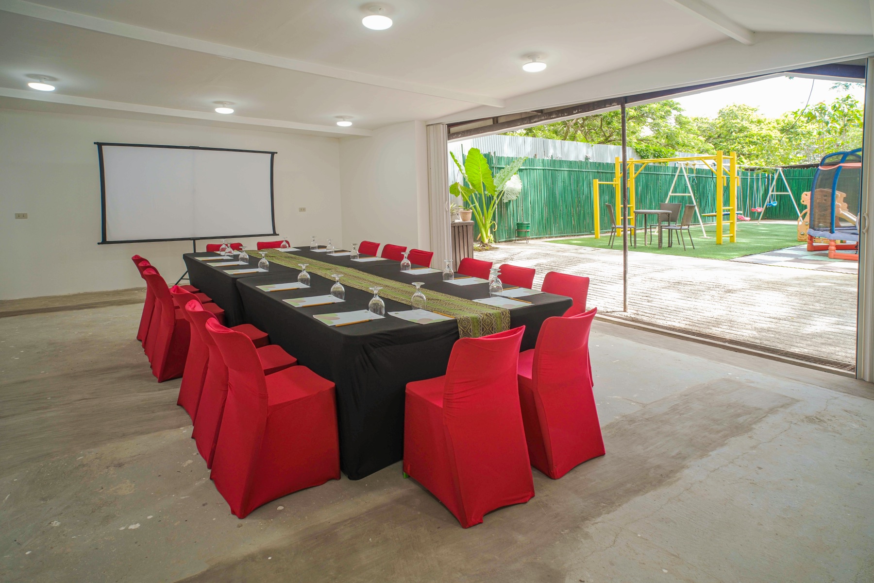 Gabe's Pavilion interior with red-draped seating and the accordion doors open onto the courtyard