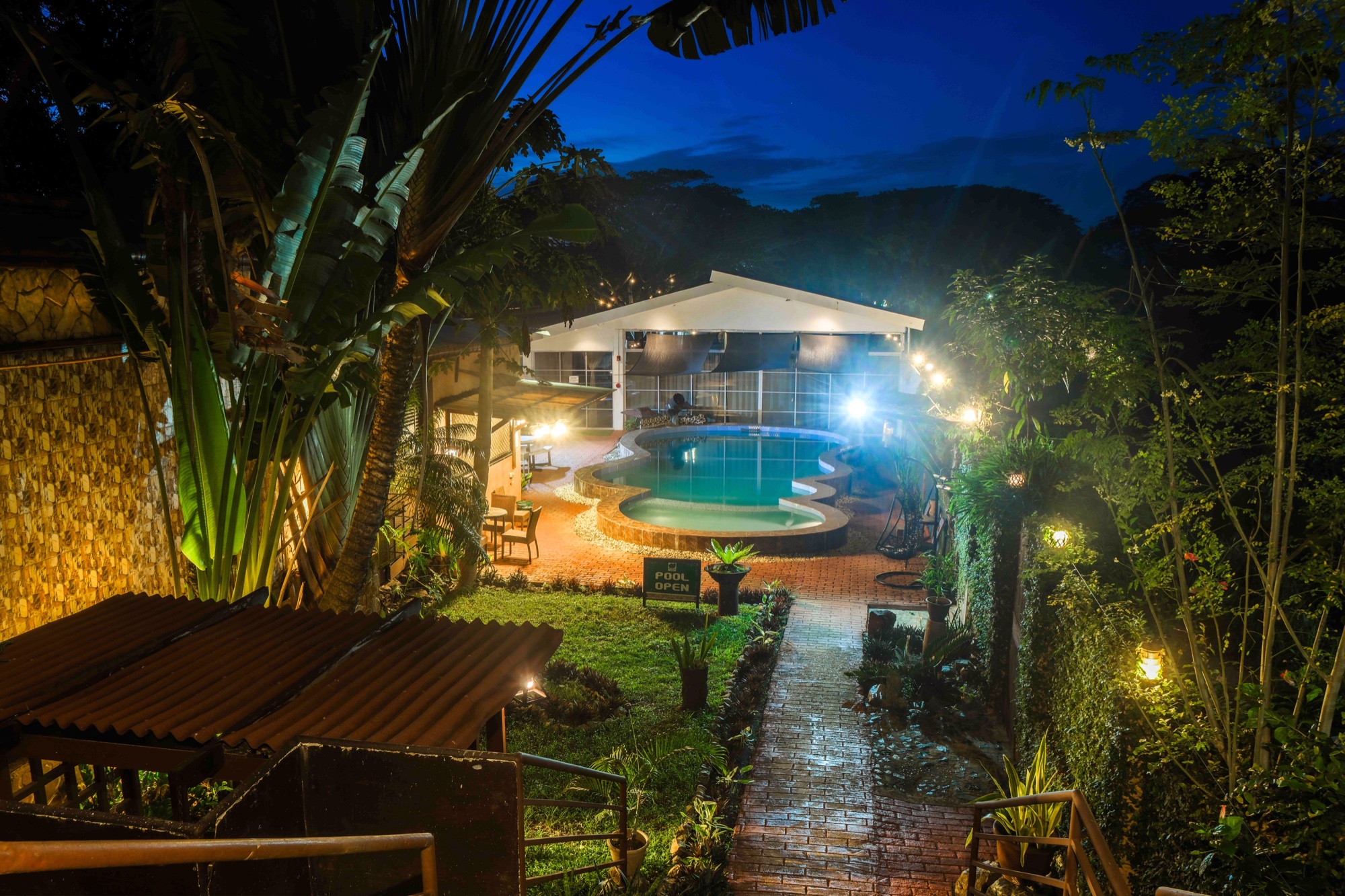 The pool and pavilion at twilight, string lights on