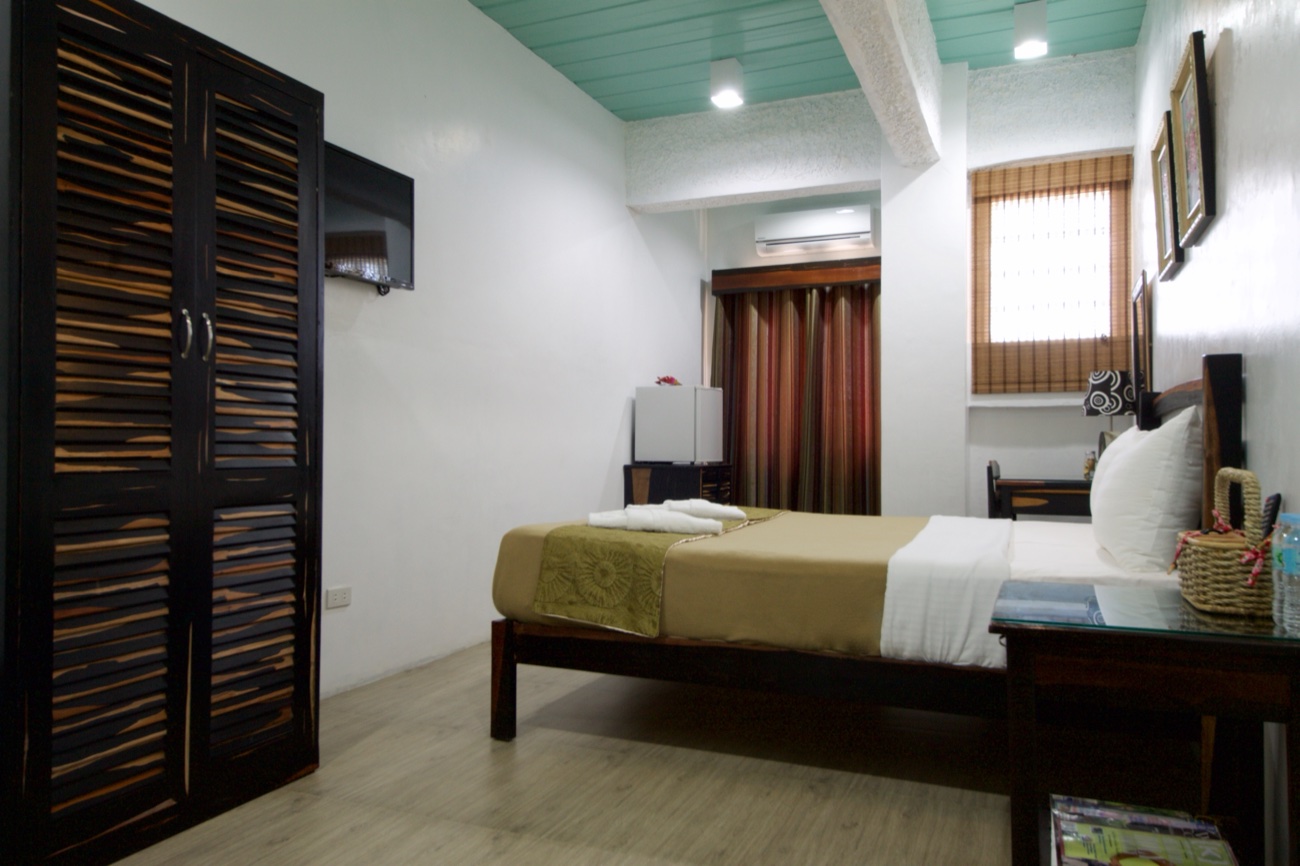 The Couple's Room, with wardrobe, TV, and a bamboo-shaded window